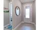 Bright entryway with tile flooring, a circular mirror, and glass door at 7675 Summerland Cv, Bradenton, FL 34202