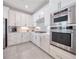 Modern kitchen with white cabinets, herringbone backsplash and stainless steel appliances at 7675 Summerland Cv, Bradenton, FL 34202