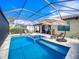 Inviting pool area with spa and covered lanai, offering ample seating and lake views at 7675 Summerland Cv, Bradenton, FL 34202