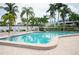 Community pool surrounded by palm trees and lush landscaping at 1007 Gulf N Dr # 106, Bradenton Beach, FL 34217