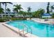 Tranquil community pool with palm trees and fencing at 1007 Gulf N Dr # 106, Bradenton Beach, FL 34217