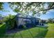 Landscaped backyard with a screened patio and lawn at 1035 Bradberry Dr, Nokomis, FL 34275