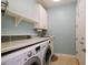 Bright laundry room with washer, dryer, and storage at 1035 Bradberry Dr, Nokomis, FL 34275