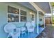 Relaxing covered porch with white wicker chairs and side table at 1524 2Nd E Ave, Bradenton, FL 34208