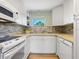White kitchen with stone backsplash and modern appliances at 2155 Wood St # B17, Sarasota, FL 34237