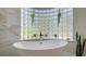 Relaxing bathroom with a large free-standing tub and glass block window at 269 Pine Ranch Trl, Osprey, FL 34229
