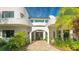 Curved white stucco home with double doors and lush landscaping at 269 Pine Ranch Trl, Osprey, FL 34229