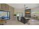 Spacious living room with fireplace, large TV, and sliding doors to patio at 269 Pine Ranch Trl, Osprey, FL 34229