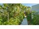 Stone path meanders through a vibrant garden at 269 Pine Ranch Trl, Osprey, FL 34229