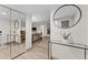 Bright entryway with glass-top table, mirror, and wood floors at 310 Wexford Ter # 164, Venice, FL 34293