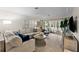 Living area with sectional sofa, coffee table, and access to a patio at 310 Wexford Ter # 164, Venice, FL 34293