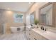 Bathroom boasts double vanity, a free-standing bathtub, and marble tile at 3408 Fair Oaks Ln, Longboat Key, FL 34228
