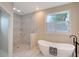 Spa-like bathroom with a soaking tub, walk-in shower, and marble tile at 3408 Fair Oaks Ln, Longboat Key, FL 34228