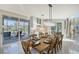 Bright dining room features a wood table, chandelier, and views to the backyard at 3408 Fair Oaks Ln, Longboat Key, FL 34228