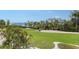 Scenic golf course view with palm trees and ocean in background at 3408 Fair Oaks Ln, Longboat Key, FL 34228