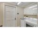 Bright laundry room with washer, dryer, and storage cabinets at 3408 Fair Oaks Ln, Longboat Key, FL 34228