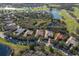 Aerial view of a community featuring homes with pools, golf course, and lush landscaping near a lake at 3769 Caledonia Ln, Sarasota, FL 34240
