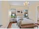 Cozy bedroom featuring stylish chandelier, wood floors, and large windows at 3769 Caledonia Ln, Sarasota, FL 34240