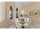 Bright dining room with chandelier, glass table, and arched windows at 3769 Caledonia Ln, Sarasota, FL 34240