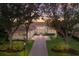 Inviting exterior view of a home at dusk, showcasing its lush landscaping, driveway, and elegant architectural details at 3769 Caledonia Ln, Sarasota, FL 34240