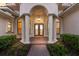 Grand front entrance with decorative glass doors, classic columns, and beautiful landscaping at 3769 Caledonia Ln, Sarasota, FL 34240
