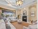 Bright living room with a fireplace and panoramic window views of the pool and backyard at 3769 Caledonia Ln, Sarasota, FL 34240