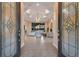 Elegant living room with decorative glass front doors, tray ceiling, and a cozy fireplace at 3769 Caledonia Ln, Sarasota, FL 34240