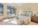 Serene main bedroom with a large window, white furniture, and wood floors, creating a light and airy atmosphere at 3769 Caledonia Ln, Sarasota, FL 34240
