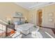 Inviting main bedroom with a view of the hallway, wood floors and bench for extra seating and comfort at 3769 Caledonia Ln, Sarasota, FL 34240