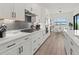 Modern kitchen with white cabinets, gas cooktop, and gray brick backsplash at 4820 Coastal Days Ln, Bradenton, FL 34211