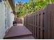 Private backyard with a wood deck, brown fence, greenery, and a grill at 4946 Brywill Cir, Sarasota, FL 34234