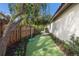Artificial turf backyard with rope swing and lush landscaping along the fence line and the side of the house at 4946 Brywill Cir, Sarasota, FL 34234