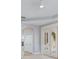 Bedroom with light hardwood floors, double doors with shutters, and a ceiling fan at 4946 Brywill Cir, Sarasota, FL 34234