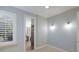 Bright bedroom with light-blue walls featuring large window with shutter, and doorway to en suite bathroom at 4946 Brywill Cir, Sarasota, FL 34234