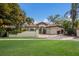Elegant single-story home with a clay tile roof, turquoise doors, a lush lawn, and a two-car garage at 4946 Brywill Cir, Sarasota, FL 34234