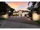Elegant home exterior with a brick driveway, lush landscaping, and a warm sunset sky at 4946 Brywill Cir, Sarasota, FL 34234