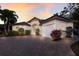 Exterior elevation of a house featuring an arched entryway, tile roof, and a brick driveway at 4946 Brywill Cir, Sarasota, FL 34234