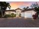 Lovely exterior of a house with tile roof, arched entryway, and a brick driveway at 4946 Brywill Cir, Sarasota, FL 34234