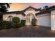 Beautiful home featuring manicured landscaping, an arched entryway, and three-car garage at 4946 Brywill Cir, Sarasota, FL 34234