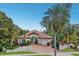 Charming single-Gathering home with a clay tile roof, tropical landscaping, a paved driveway, and a two-car garage at 4946 Brywill Cir, Sarasota, FL 34234