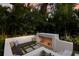 Outdoor seating area with a cozy fireplace and a built-in bench with comfortable pillows, surrounded by greenery at 4946 Brywill Cir, Sarasota, FL 34234