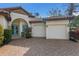 Close-up exterior view of the house with a two-car garage, clay tile roof, and decorative archway over the front door at 4946 Brywill Cir, Sarasota, FL 34234