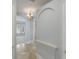 Elegant hallway with travertine floors, arched doorways, and a decorative chandelier at 4946 Brywill Cir, Sarasota, FL 34234