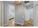 Hallway featuring decorative chandelier and leading to a bathroom with elegant finishes at 4946 Brywill Cir, Sarasota, FL 34234
