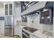 Modern kitchen with stainless steel appliances, custom range hood, and updated backsplash at 4946 Brywill Cir, Sarasota, FL 34234