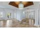 Elegant living space with travertine floors, custom lighting, a decorative ceiling, and doors leading to outdoor spaces at 4946 Brywill Cir, Sarasota, FL 34234