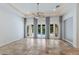 Light-filled living space with travertine floors, neutral walls, ceiling fan, and multiple sliding glass doors to the pool area at 4946 Brywill Cir, Sarasota, FL 34234