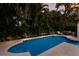 Inviting backyard pool featuring a sleek design, surrounded by lush tropical landscaping and a lounge chair at 4946 Brywill Cir, Sarasota, FL 34234