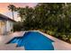 Backyard pool featuring tiled entry, surrounded by well-maintained tropical plants, creating a serene oasis at 4946 Brywill Cir, Sarasota, FL 34234