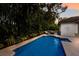 Relaxing backyard pool area surrounded by tropical greenery, with a comfortable lounge chair and a peaceful ambiance at 4946 Brywill Cir, Sarasota, FL 34234